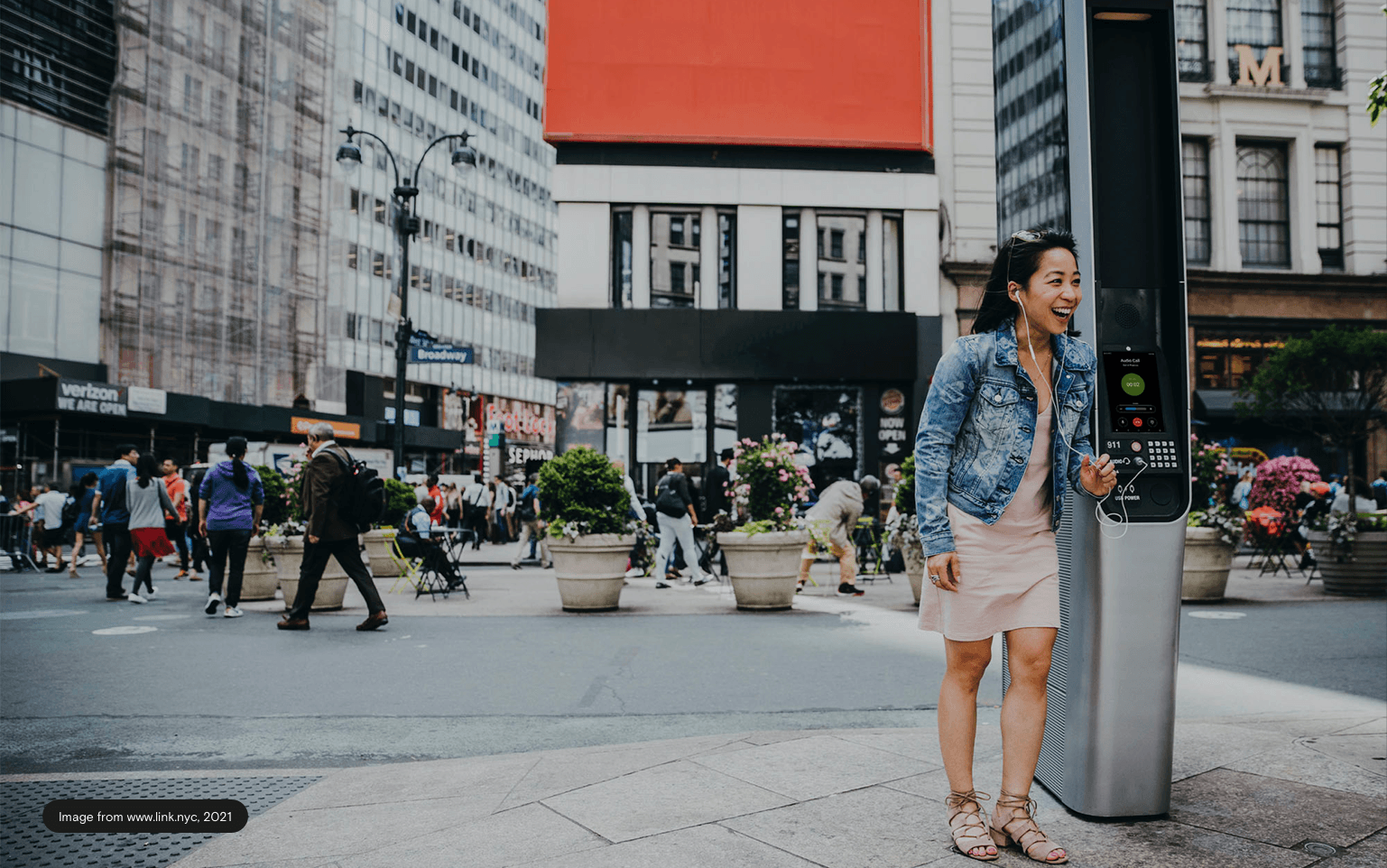 Smiling woman next the LinkNYC booth